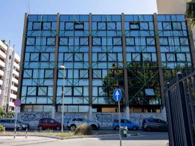 Veniamo poi attratti da un palazzo a vetri a forma di L, con una romboidale �rete� metallica verde che ne contraddistingue il prospetto
